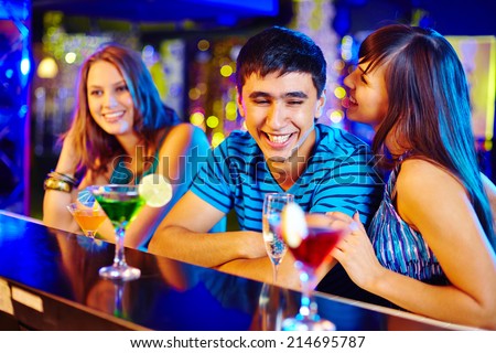Portrait of pretty girl flirting with guy at party in the bar