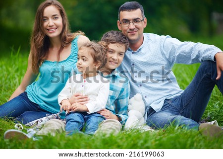 Happy parents and their children enjoying weekend in the park