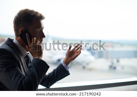 Elegant businessman speaking on cellular phone in airport
