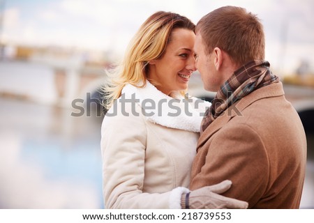 Portrait of amorous man and woman standing face to face outside