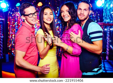 Portrait of two couples clubbing at night