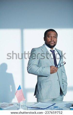African-american employee in suit standing in office