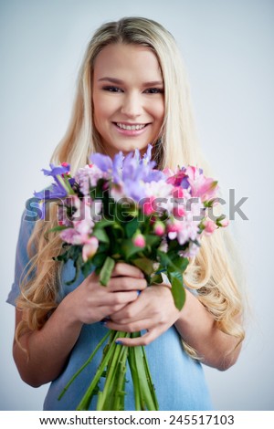 Smiling female with flowers looking at camera
