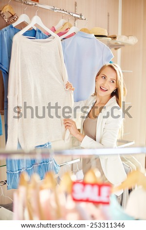 Beautiful young woman choosing new pullover