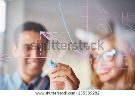 Businessman sketching graph on transparent board with highlighter