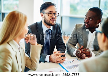 Serious businessman explaining his ideas to managers at meeting