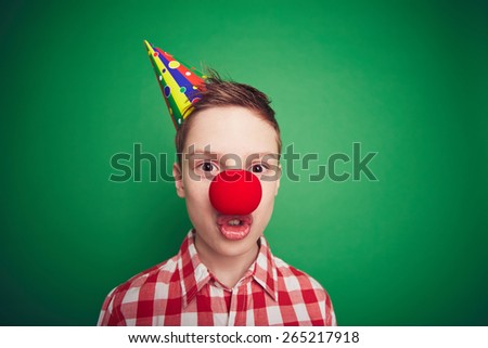 Cute boy with red clown nose grimacing