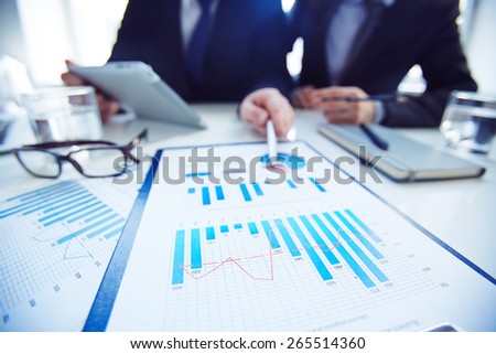 Close-up of two businessmen discussing marketing review at meeting