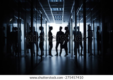 Silhouettes of managers having business meeting in corridor of office building
