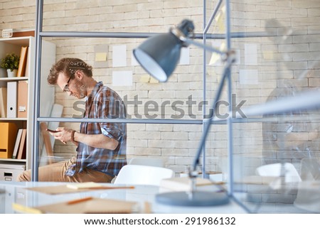 Modern businessman writing sms in office