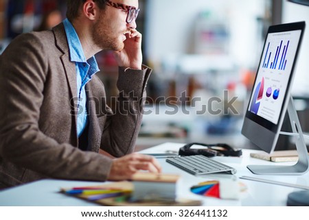 Male office worker sitting in front of computer