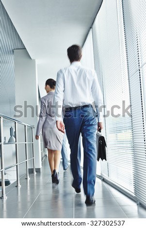Backs of business people in formalwear hurrying for work