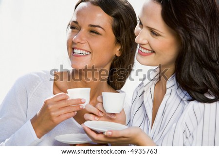 Portrait of two business women holding cups of coffee in their hands