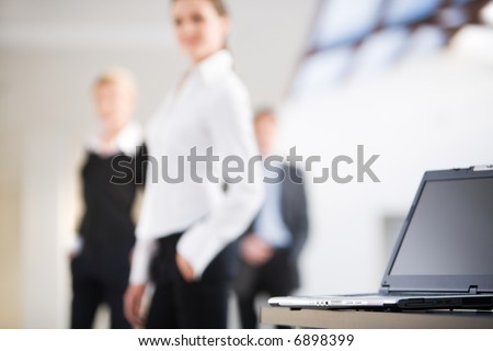 Photo of black laptop on the background of business people