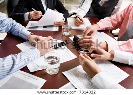 Image of different hands at business meeting