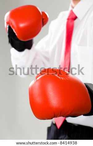 Vertical photo of a business man in red boxing gloves
