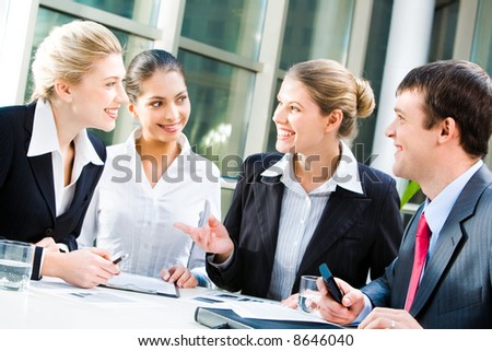 Four business people sitting at the table and discussing a project