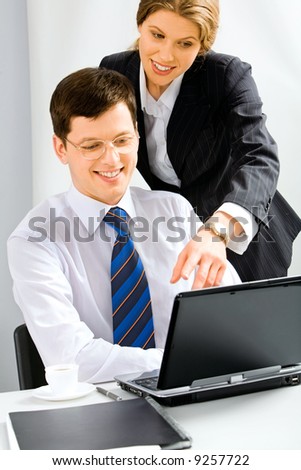Executive secretary is explaining the correct way of report to her boss pointing at the monitor of laptop