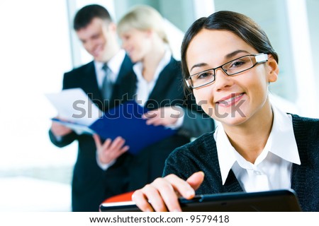 Image of clever woman looking at camera on the background of people