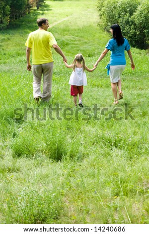 Image of backs of family walking in the forest