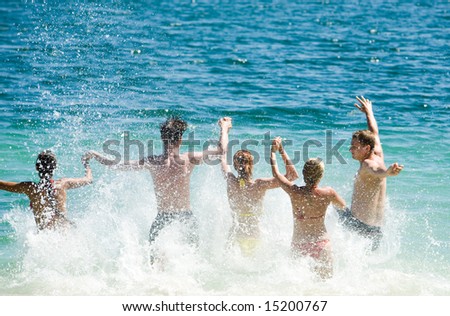 Portrait of five young people running in the lake all together