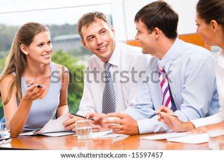 Portrait of several business people sitting in office and discussing new plans and ideas