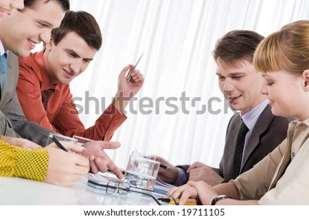 Photo of confident people speaking during meeting in office