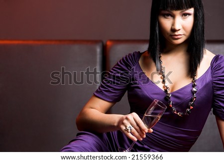 Portrait of elegant female with flute of champagne looking at camera