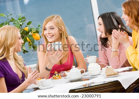 Friendly conversation of four pretty girls during lunch