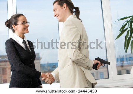Portrait of smiling woman shaking hand of man with gun hidden behind his back