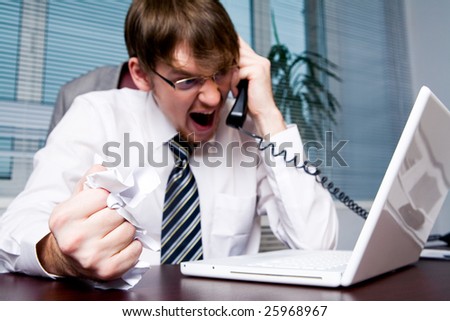 Image of aggressive boss yelling into telephone receiver to one of his employees