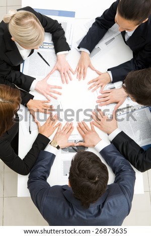 Above view of business partners making circle from hands on table