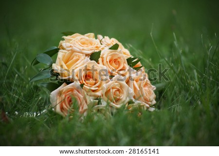 Close-up of bridal yellow rose bouquet in green grass