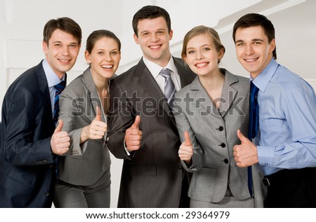 Portrait of happy co-workers looking at camera with smiles and showing sign of okay