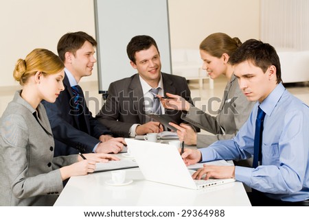 Portrait of confident colleagues working while confident woman sharing her idea with co-workers on background