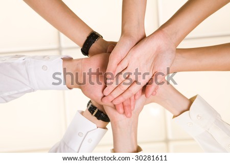 Below view of business partners? hands making pile as symbol of companionship and unity