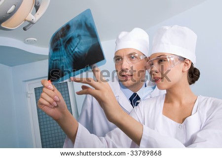 Image of young lady with dentist showing her x-ray photography