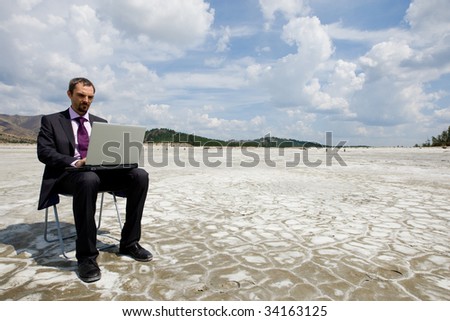 Photo of modern businessman typing on laptop outside with cloudy sky above
