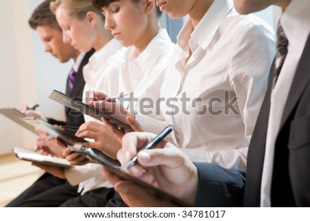 Row of business people writing lecture at conference