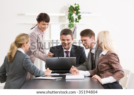 Photo of confident business people looking at laptop monitor while woman explaining something to them