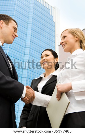 Image of successful partners handshaking after signing an agreement