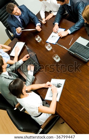 Above view of young co-workers planning work at meeting