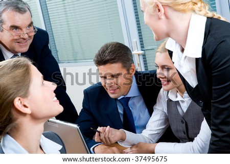 Portrait of confident co-workers interacting with each other while pretty female explaining something