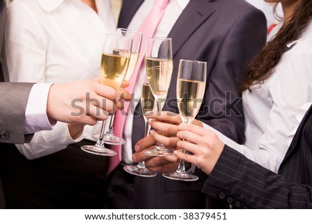 Close-up of human hands cheering up with flutes of sparkling champagne