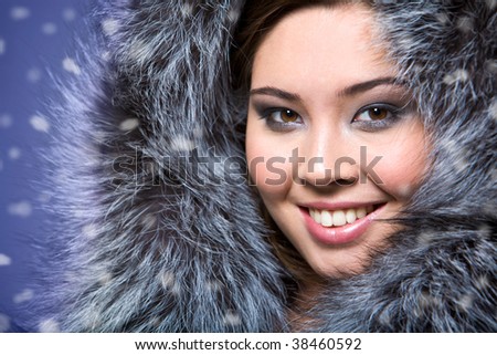 Portrait of beautiful female wearing fur cap and smiling