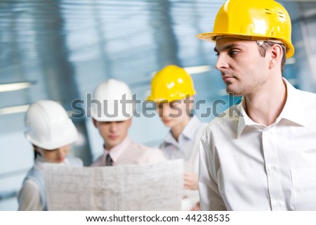 Portrait of confident foreman in helmet in working environment