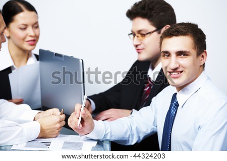 Photo of happy man looking at camera in working environment