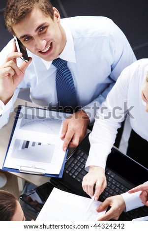 Above view of businessman looking at camera while speaking on the phone