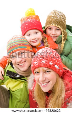 Happy family in winter clothes looking at camera and smiling