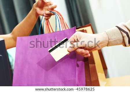 Close-up of man?s hand passing over credit card to shop assistant after shopping